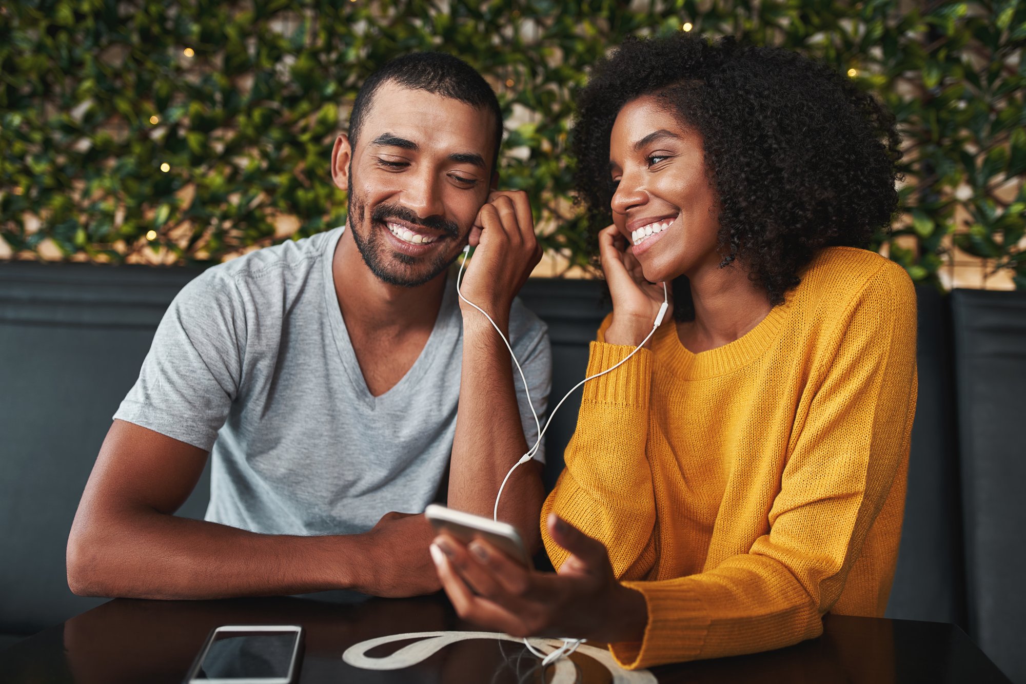 Portrait of a young couple together listening to music on one earphone